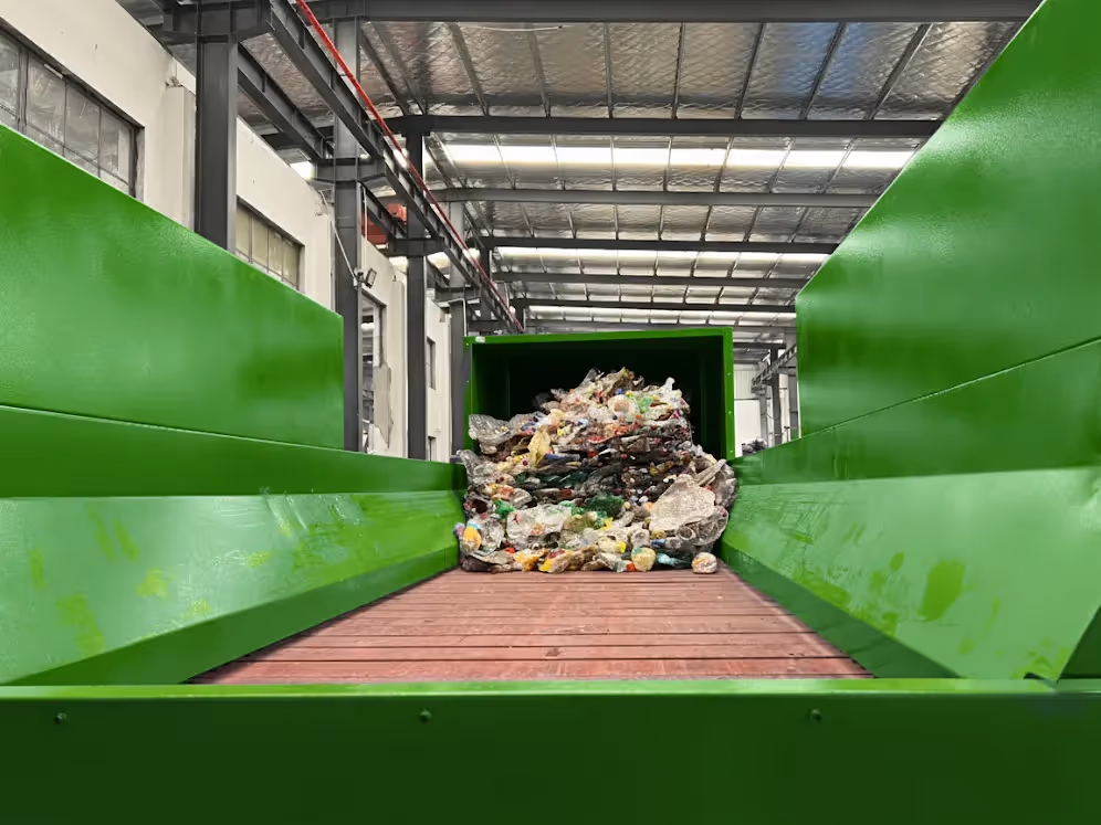 Debaler machine infeed for breaking compacted plastic bottle bales.